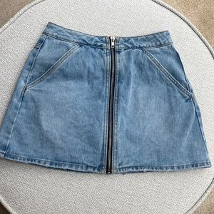 Top to bottom zipper jean skirt. Front angled pockets. Light wash. Size Small.